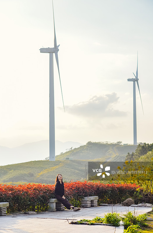 一位亚洲女性在浙江宁波鄞州区横溪镇白岩山山水印最美风车公路欣赏风力发电机组秋日风景图片素材