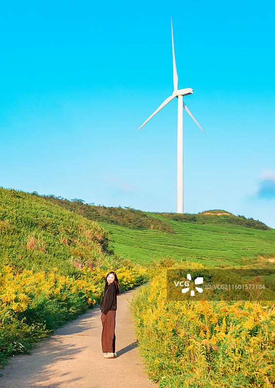一位亚洲女性在浙江宁波鄞州区横溪镇白岩山山水印最美风车公路欣赏风力发电机组秋日风景图片素材