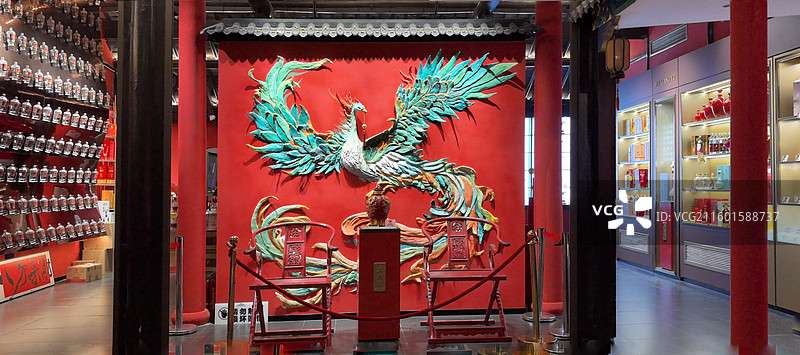 凤影红墙 红墙之上彩凤展翅，前设朱椅，左列酒器成阵，右柜陈酿生辉，古雅中透着酒香。图片素材