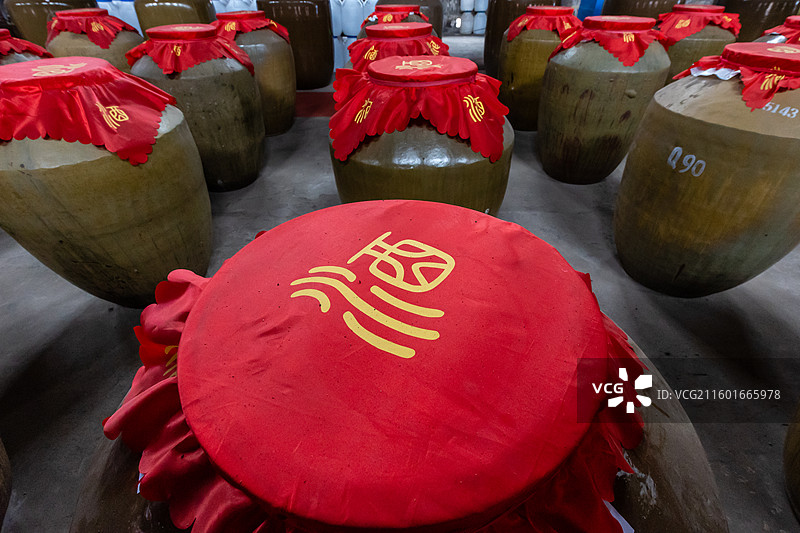 白酒酒厂展示中的窑藏存放于仓库的大酒坛图片素材