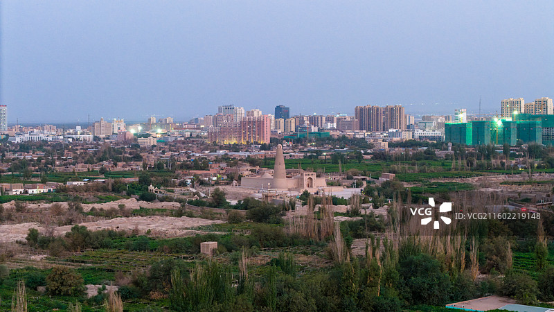 新疆吐鲁番市，黎明时分的城市天际线，前景可见地标建筑苏公塔。图片素材