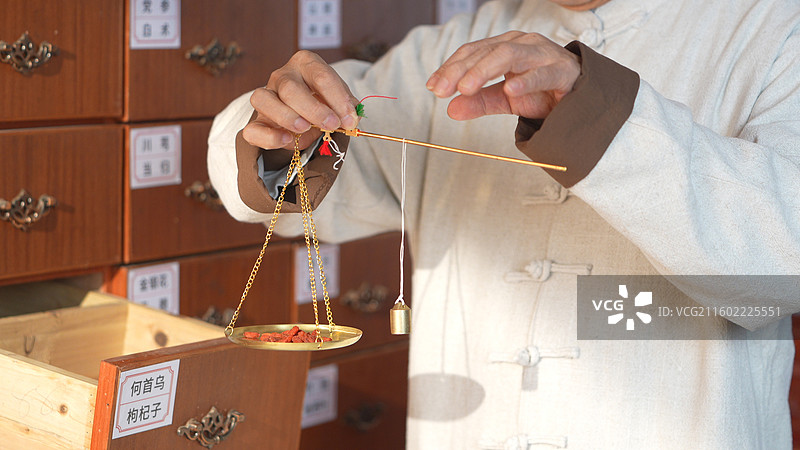 手拿称称药材的老年医生图片素材