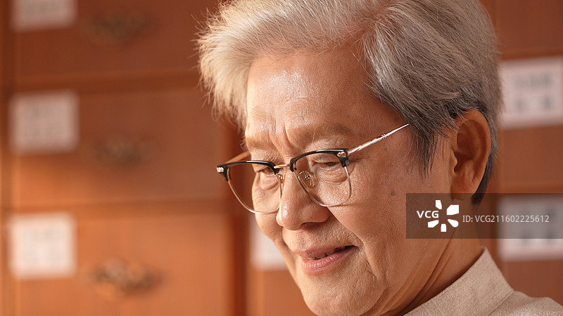 手拿称称药材的老年医生图片素材