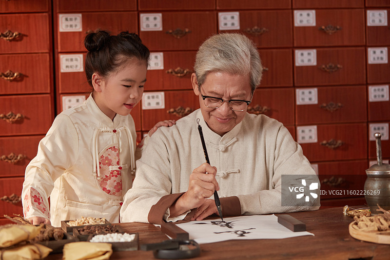 站在爷爷旁边临摹书法的小女孩图片素材
