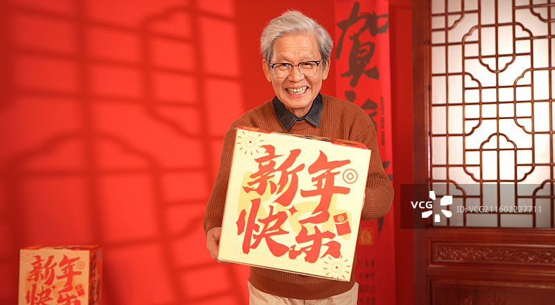 手拿大礼盒的老年男人图片素材