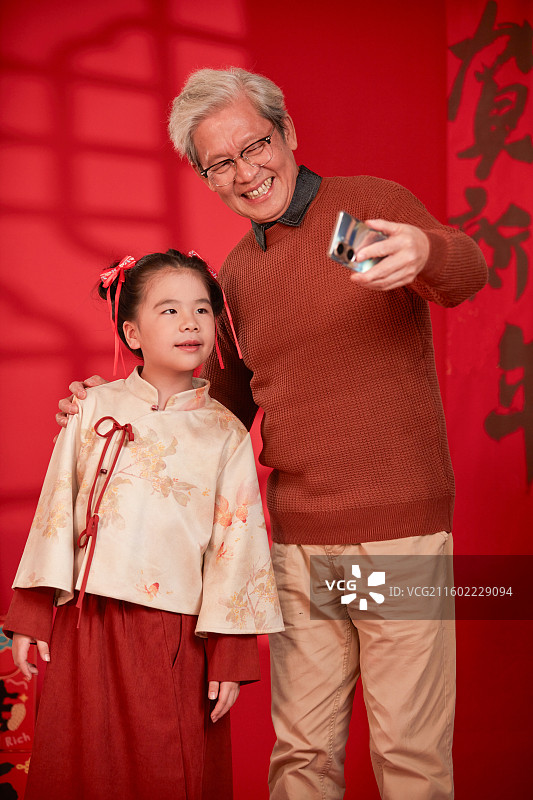 使用手机拍合影的爷爷与孙女图片素材