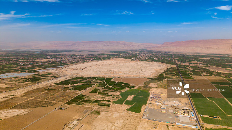 新疆吐鲁番市，高昌故城（航拍视角）；周围是木头沟河绿洲的农田和大棚，远景为火焰山。图片素材