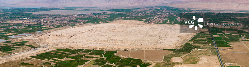 新疆吐鲁番市，高昌故城（航拍视角）；周围是木头沟河绿洲的农田和大棚，远景为火焰山。图片素材