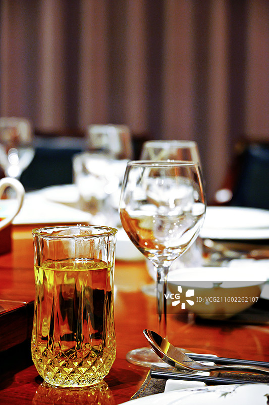 餐桌上摆放的茶杯啤酒杯餐盘筷子餐勺图片素材