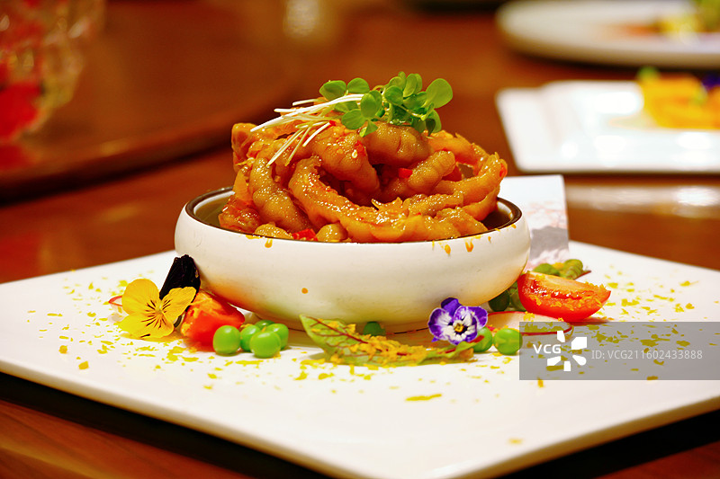 餐桌白色瓷盘里摆放的凉拌去骨凤爪特写图片素材