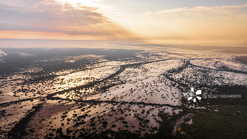 这张航拍图展现了江苏省盐城市条子泥的绝美景观。画面中，天空中云彩被染成温暖的橙色调图片素材