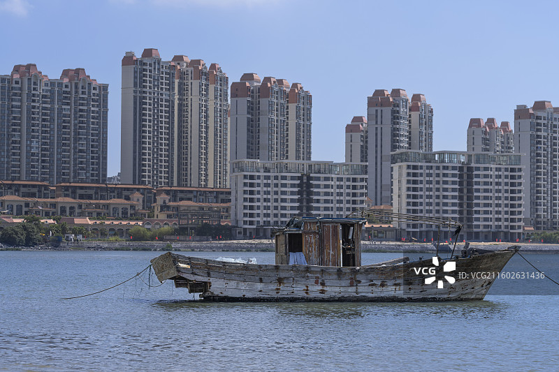 北海银滩：城市与水岸：旧渔船与现代建筑的共生图景图片素材