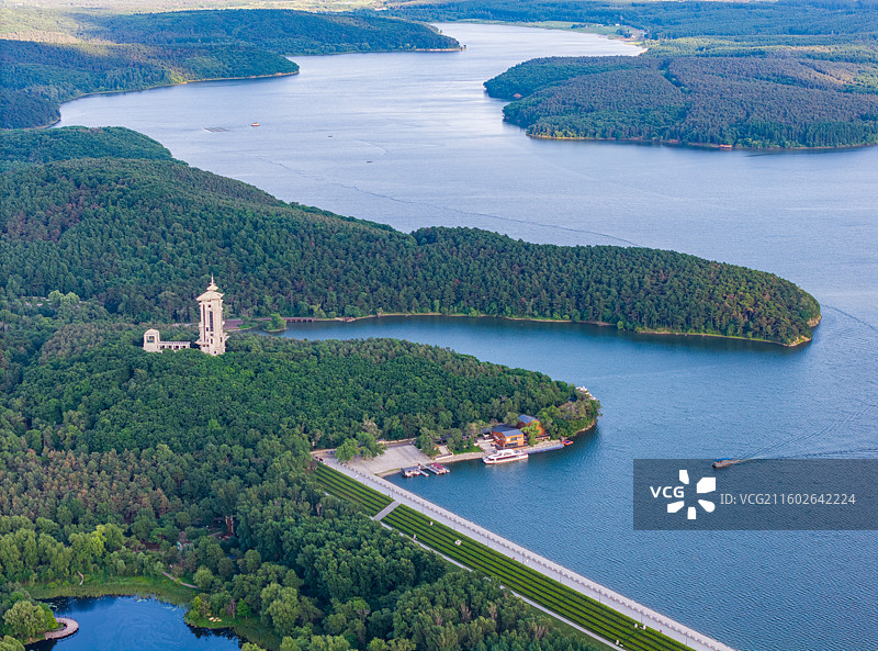 中国吉林省长春市净月潭国家森林公园-净月潭水库大坝与碧松净月塔楼夏季日落时分高视角航拍全景图图片素材