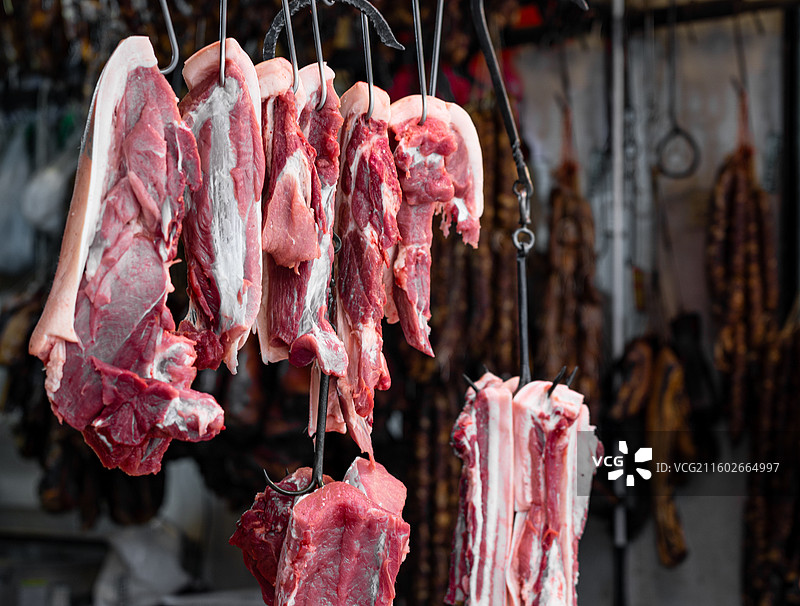 中国传统菜市场上铁钩子上悬挂售卖的猪肉五花肉图片素材