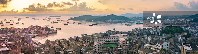 温岭石塘小箬村麒麟山全景，彩色渔村与海港日落相映，展现海岛独特风光。图片素材