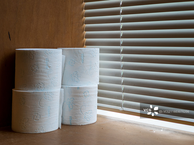 百叶窗旁白色卫生纸卷堆图片素材