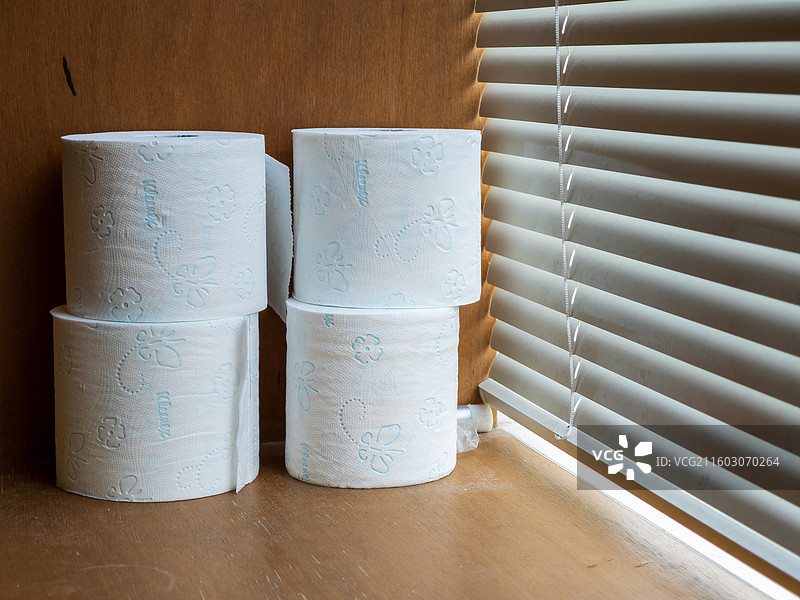 百叶窗旁白色卫生纸卷堆图片素材