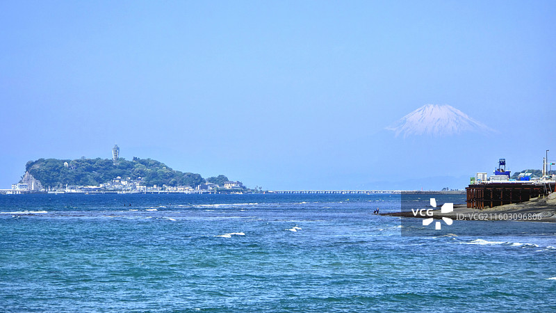 日本神奈川县镰仓市，从稻村崎眺望晨雾中的富士山和江之岛图片素材