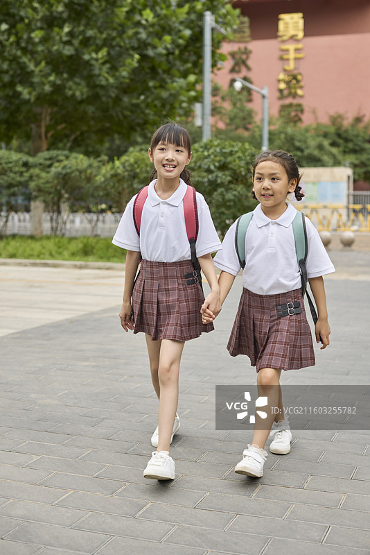 两个小女孩一起牵手放学图片素材