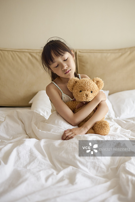 瞌睡的小女孩抱着玩具熊图片素材