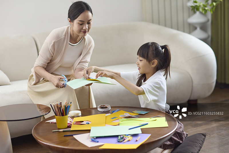 妈妈陪伴女儿做手工作业图片素材