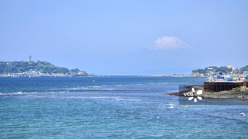 日本神奈川县镰仓市，从稻村崎眺望晨雾中的富士山和江之岛图片素材