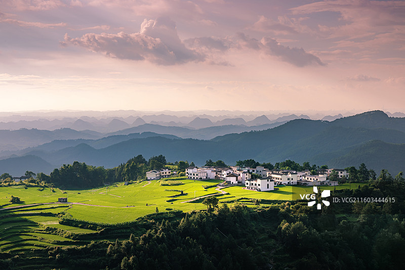 傍晚夕照中的高山上村庄与梯田图片素材
