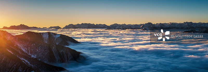 日照雪山与云海，群峰从云海中出图片素材