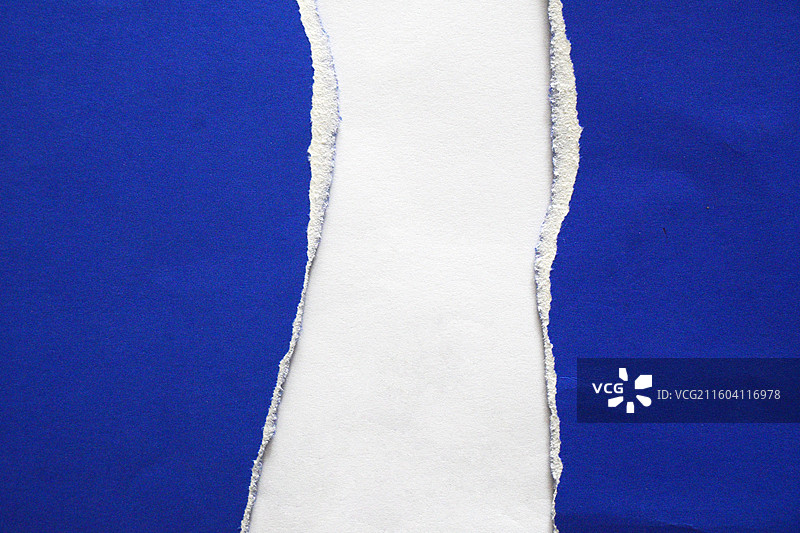 蓝色背景上的白色撕裂布料图片素材