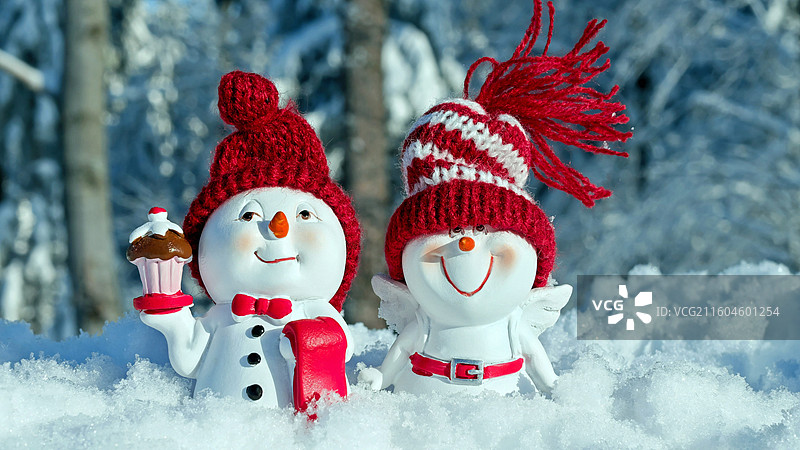 两个红白相间的雪人雕像，站立着，雪地，雪人，有趣，人物，滑稽，戴着帽子，雪脸，冬天图片素材