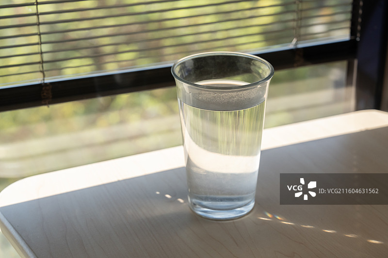 百叶窗边桌上的水杯特写，纯净水图片素材