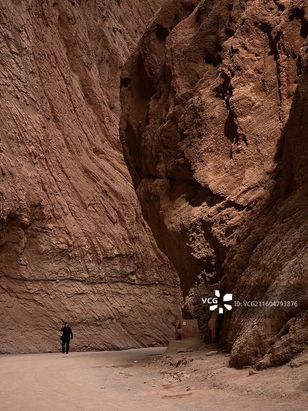 晴天红色岩石纹理雅丹丹霞地貌峡谷转弯处有人图片素材