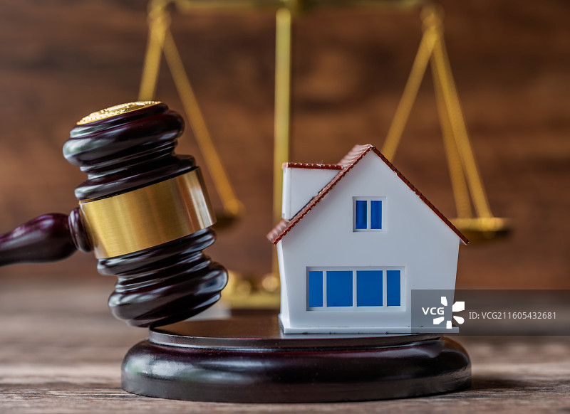 法槌、天平、房屋模型与棕褐色实木背景图片素材