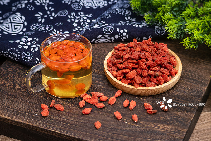 桌面木盘里放满晒干的中药材枸杞子食品原料图片素材