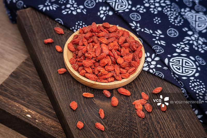 桌面木盘里放满晒干的中药材枸杞子食品原料图片素材