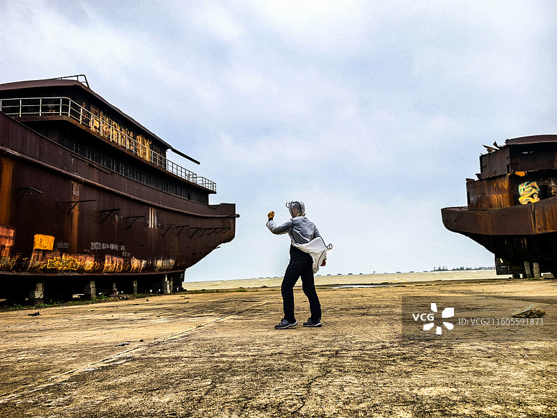 中国海口市一旧船厂几搜废弃的半成品轮船，在一搜废弃轮船发动机仓里的超现实主义人像拍摄图片素材