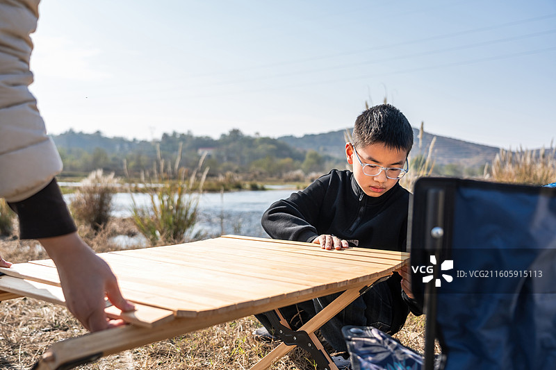 两人在户外湖边搭建折叠桌露营图片素材