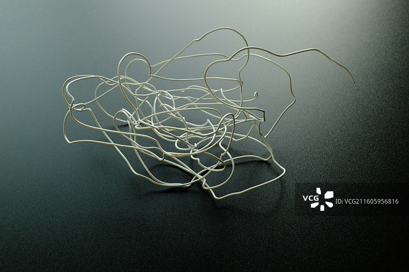 黑色背景下扭曲弯曲的白色铁丝金属丝。迷茫混乱复杂杂乱乱七八糟图片素材