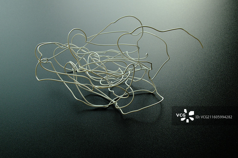 黑色背景下扭曲弯曲的白色铁丝金属丝。迷茫混乱复杂杂乱乱七八糟图片素材