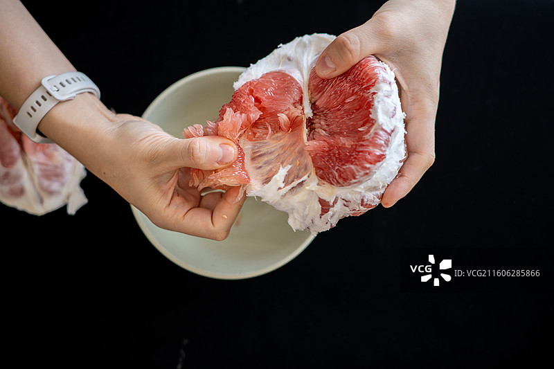 双手剥红柚子图片素材