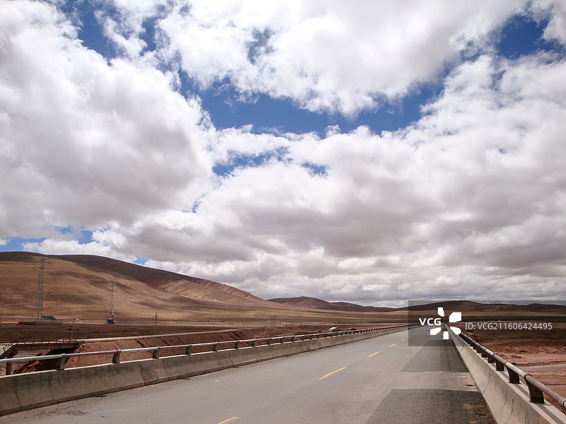 荒漠中开阔公路与多云天空图片素材