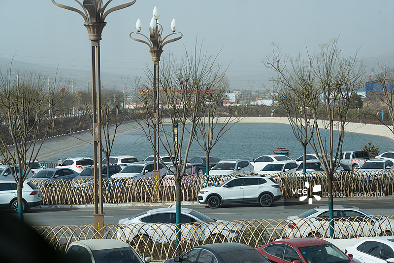 冬季的黄土高原上灰黄的大地上一个人工湖泛着美丽的湖蓝色图片素材