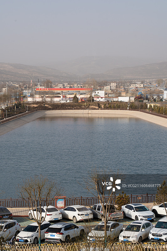 冬季的黄土高原上灰黄的大地上一个人工湖泛着美丽的湖蓝色图片素材