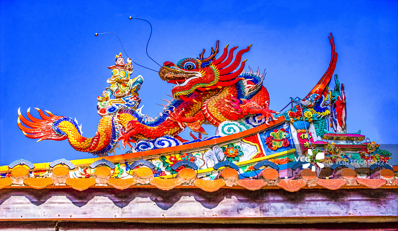 蓝天下福建泉州浔埔顺济宫妈祖宫左侧青龙飞檐花鸟脊墙龙太子骑金黄红色祥龙精美绝伦雕塑彩绘嵌瓷图片素材