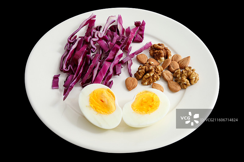 黑色背景上的一盘子营养健康早餐鸡蛋紫甘蓝坚果特写图片素材