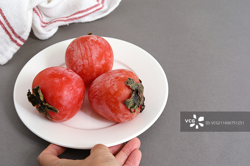 桌面上摆放着秋天里丰收的果实柿子图片素材