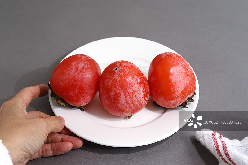 桌面上摆放着秋天里丰收的果实柿子图片素材