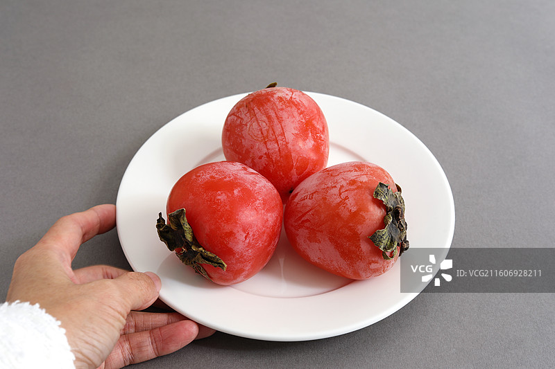 桌面上摆放着秋天里丰收的果实柿子图片素材