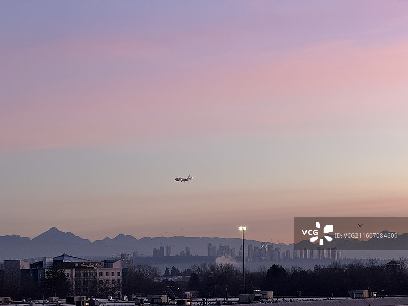 日出时分渐变色的绚烂朝霞和天车地铁站及海鸥和远山图片素材