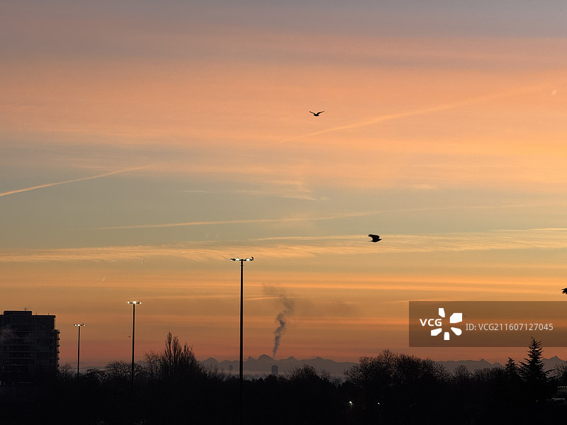 日出时分渐变色的绚烂朝霞和天车地铁站及海鸥和远山图片素材